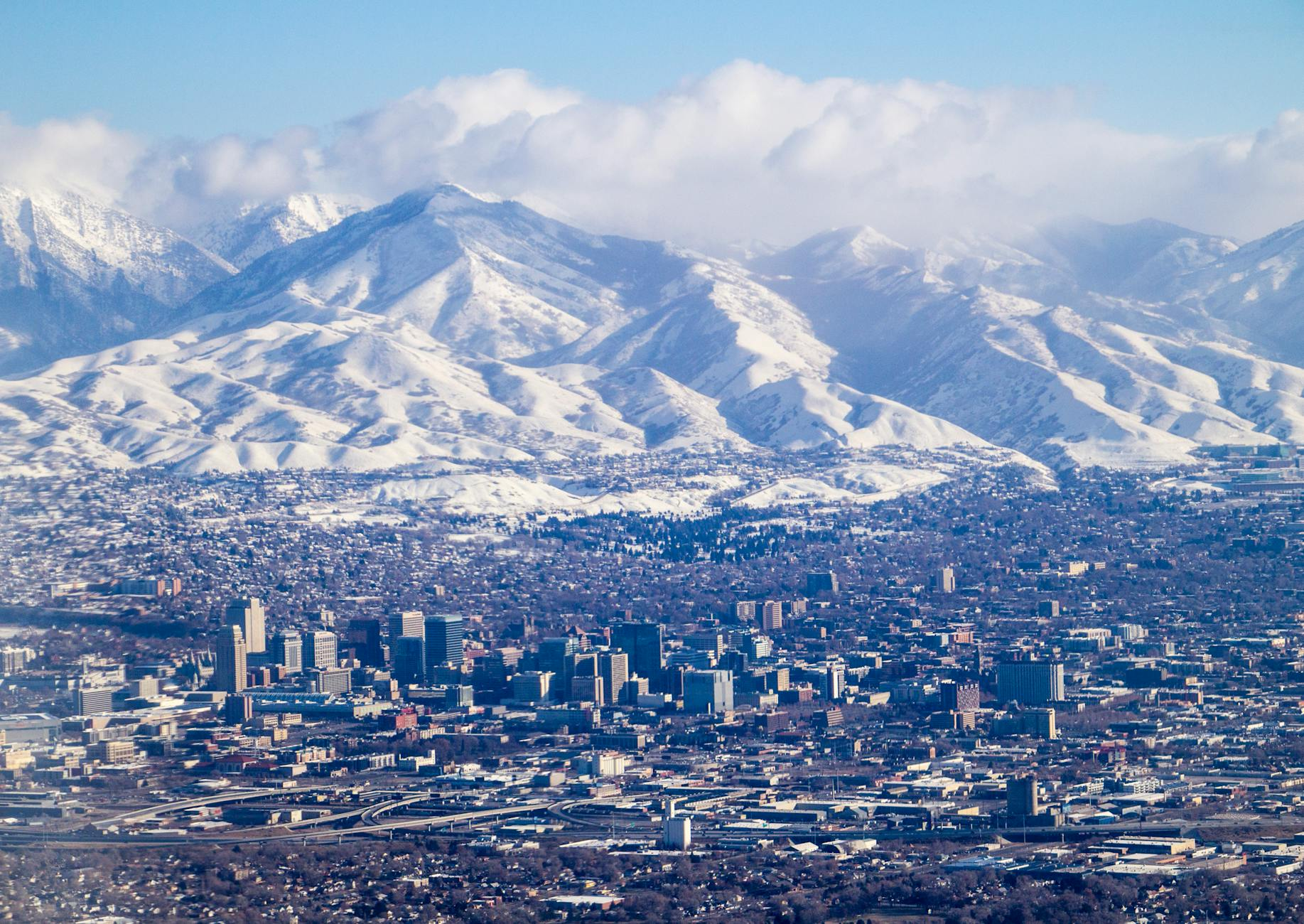 aerial view of a city by the snowy mountains